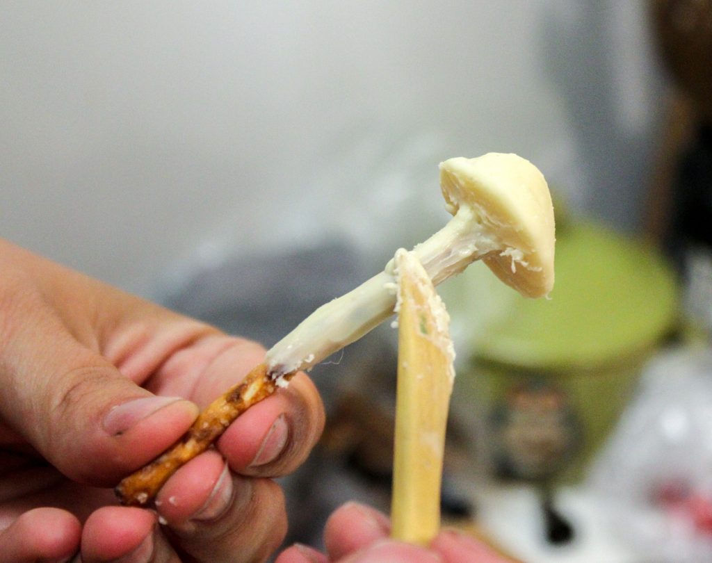 hand holding chocolate mushroom being worked on with wooden tool